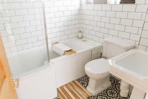 a white bathroom with a toilet and a sink at Aldaniti in Findon