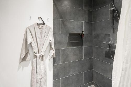 a robe hanging in a bathroom with a shower at Fantastic apartment wprivate terrace in Aarhus