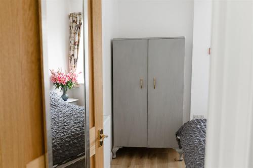 a hallway with a white cabinet and a mirror at Aldaniti in Findon
