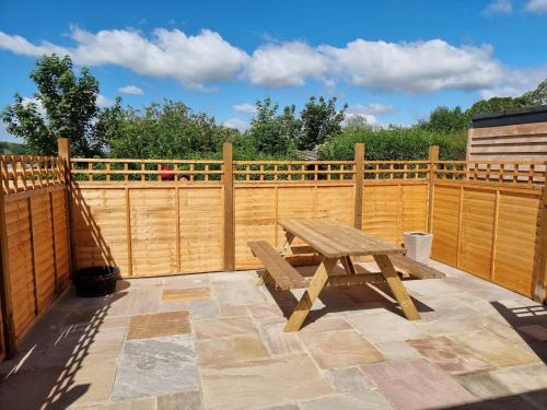 a wooden fence with a wooden picnic table on a patio at Aldaniti in Findon