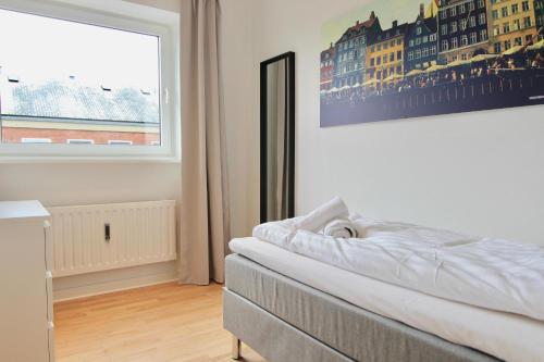 a bedroom with a bed and a large window at Fantastic 2-bed in Frederiksberg C in Copenhagen