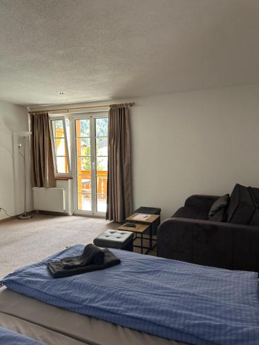 a living room with a bed and a couch at Touristenheim Bergfreude in Leukerbad