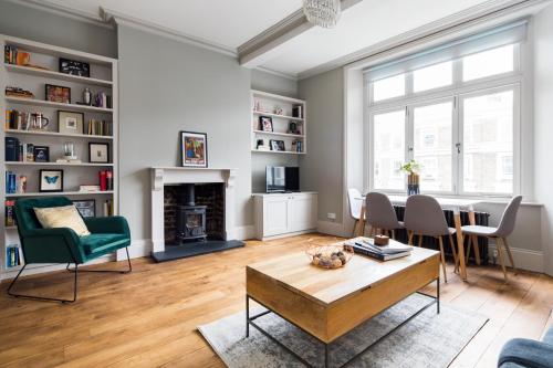 a living room with a table and chairs and a fireplace at Homely Parkside 2-Bed Apartment in Primrose Hill in London