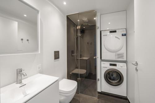 Top-class 1-bedroom apartment in Odense في أودنسه: حمام مع غسالة ومرحاض