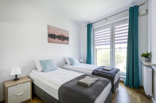 1 Schlafzimmer mit 2 Betten und einem Fenster in der Unterkunft Labo Apartment Kamionek in Warschau
