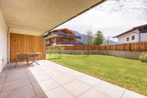 a patio with a table and a lawn at Kitzbühel Suites by ALPS RESORTS in Oberndorf in Tirol