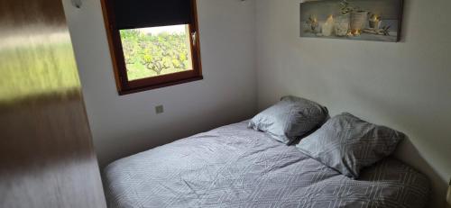 un lit dans une chambre avec une fenêtre dans l'établissement Maison à louer en Ardèche du sud, à Saint-Martin-dʼArdèche