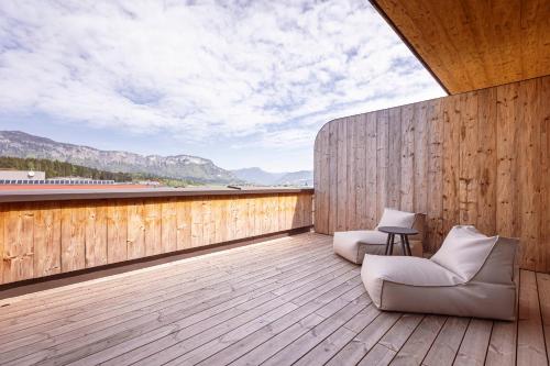a balcony with two chairs on a wooden deck at Kitzbühel Suites by ALPS RESORTS in Oberndorf in Tirol