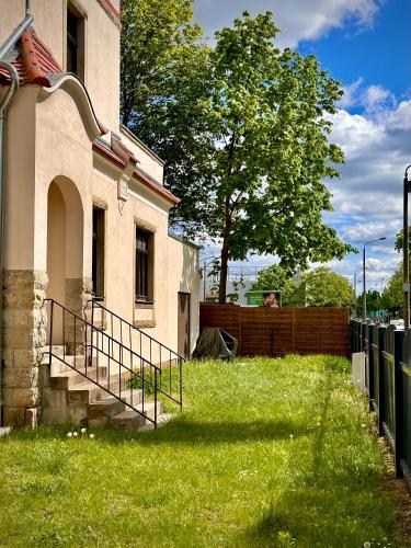 a house with a fence and a grass yard at Villarina in Dresden