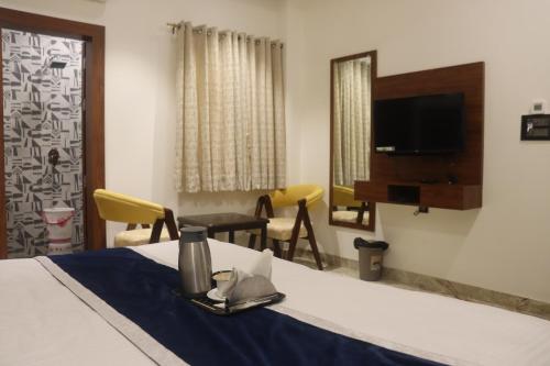 Zimmer mit einem Bett, einem Tisch und einem Spiegel in der Unterkunft Guru Kripa sadan in Vrindāvan