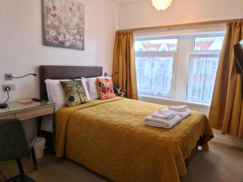 1 dormitorio con cama, escritorio y ventana en Torland Seafront Hotel - all rooms en-suite, free parking, wifi, en Paignton