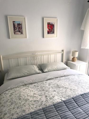 a bed in a bedroom with two pictures on the wall at Socratous House in Salamís