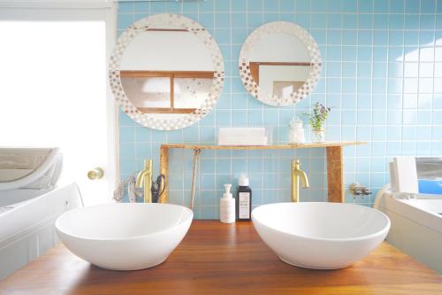 a bathroom with two white bowls on a wooden floor at AKARIYA Hostel in Karatsu