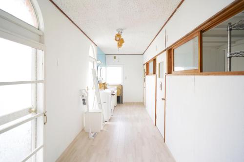 baño con un pasillo largo con lavamanos y espejos en AKARIYA Home&Hostel, en Karatsu