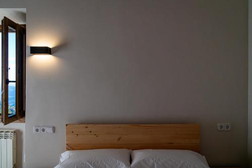 - une chambre avec un lit et une tête de lit en bois dans l'établissement Santuari de Santa Maria de Montgrony, à Gombreny