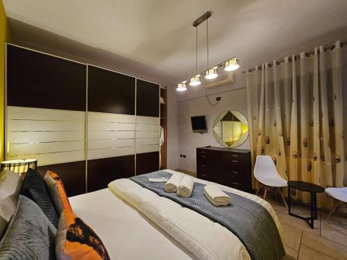 a bedroom with a bed and a chair and a mirror at Center Apartment Easy in Tirana