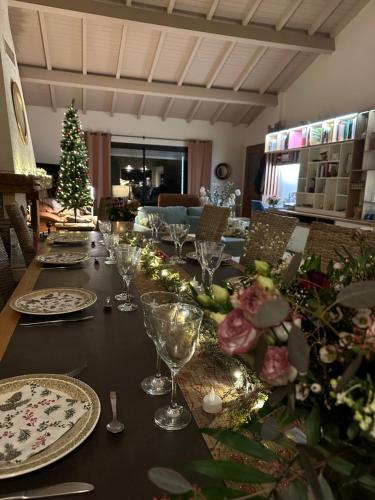 une grande table avec des assiettes et des verres et un sapin de Noël dans l'établissement Plumage, à Mercenac