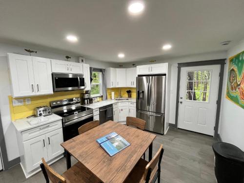 a kitchen with white cabinets and a wooden table at Bear Run Bungalow in Hawley