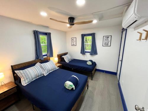 a bedroom with two beds and two windows at Bear Run Bungalow in Hawley
