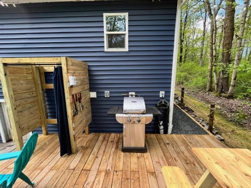 a wooden deck with a sink on a blue house at Bear Run Bungalow in Hawley