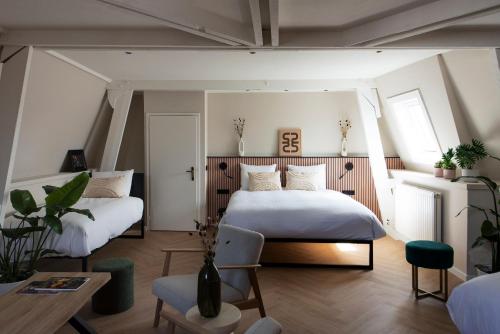 een slaapkamer met 2 bedden en een tafel bij Stadsherberg de Poshoorn in Maastricht