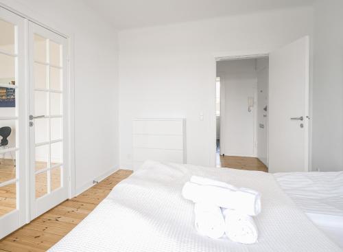 a white bedroom with white walls and a bed with two pillows at 2-BR apartment with a balcony in Charlottenlund - 192 in Charlottenlund