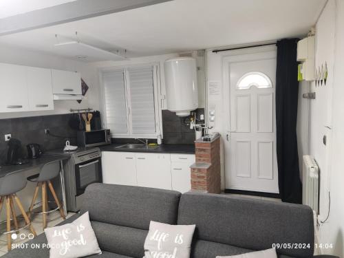un salon avec un canapé et une cuisine dans l'établissement Maison calme, clim, Smart TV, wifi , coeur Saint-Amand, à Saint-Amand-les-Eaux