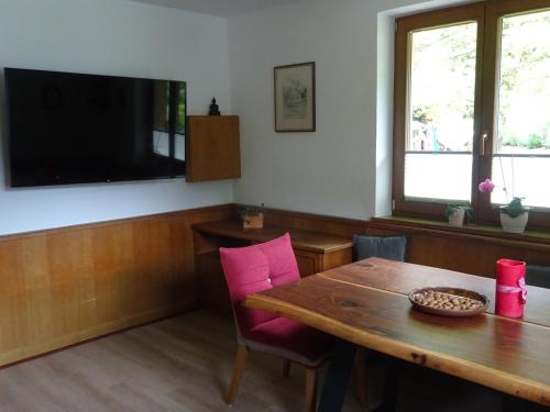 een eetkamer met een tafel en een flatscreen-tv bij Ferienwohnung Rita Kröll in Mayrhofen