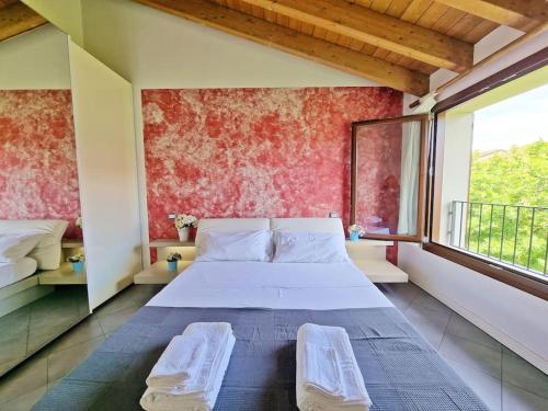 1 dormitorio con cama y ventana grande en Pool relax - Castelnuovo del garda - Garda Lake - Private Parking, en Sandra