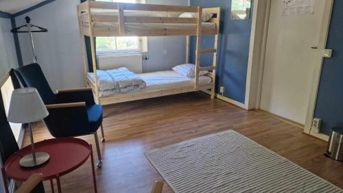 a room with two bunk beds and a table and a chair at Charlottsborgs Camping, Vandrarhem och Ställplats in Kristianstad