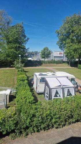 a camper and a trailer parked in a parking lot at Charlottsborgs Camping och Vandrarhem in Kristianstad