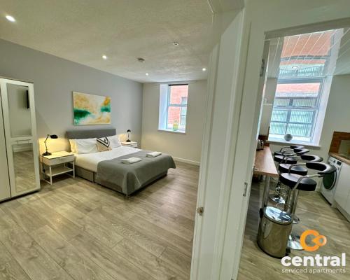 een slaapkamer met een bed en een bureau in een kamer bij 2 Bedroom Apartment by Central Serviced Apartments - Seagate - Close City Centre or Universities - Sleeps 4 1 x Double 2 x Single - Short Term Stays Welcome - Walk away from Train & Bus Station - Bus Routes to all over Dundee close by in Dundee