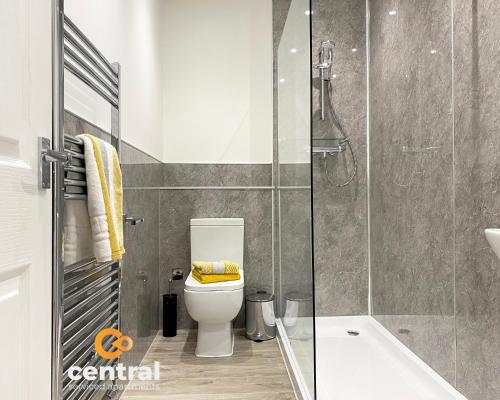 La salle de bains est pourvue de toilettes et d'une douche en verre. dans l'établissement 2 Bedroom Apartment by Central Serviced Apartments - Seagate - Close City Centre or Universities - Sleeps 4 1 x Double 2 x Single - Short Term Stays Welcome - Walk away from Train & Bus Station - Bus Routes to all over Dundee close by, à Dundee