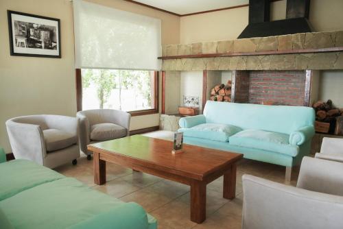 a living room with a blue couch and a coffee table at Sent Calafate in El Calafate
