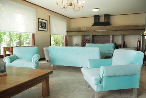- un salon avec des chaises bleues et une table dans l'établissement Sent Calafate, à El Calafate