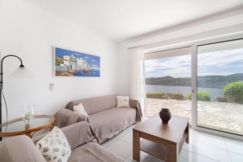 a living room with a couch and a large window at Villa Asossa with Private pool & Sea view in Dhaskalión