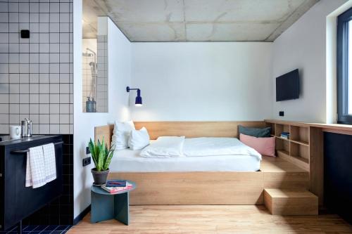 a small bedroom with a bed and a bathroom at STAYERY Berlin Friedrichshain in Berlin