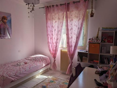 - une chambre avec un lit et une fenêtre avec des rideaux roses dans l'établissement Appartement 3 chambres - 2 salles de bain - 6 personnes, à Ajaccio