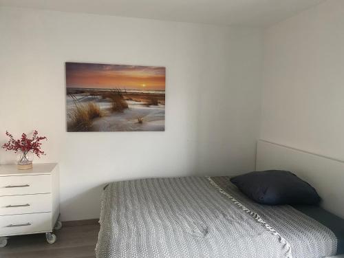 1 dormitorio con 1 cama y una pintura en la pared en Gemütliches Zuhause in 1A Lage en Herne