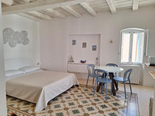 Schlafzimmer mit einem Bett, einem Tisch und Stühlen in der Unterkunft COMES 33 HOME in Monopoli