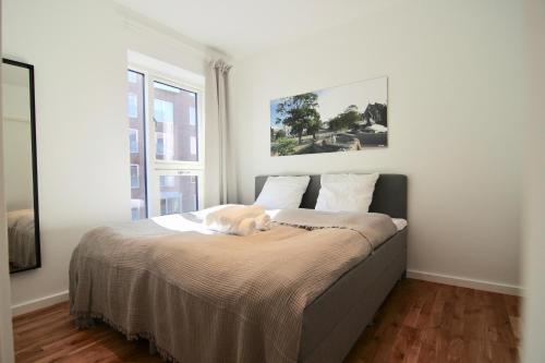 a dog laying on a bed in a bedroom at Fantastic 2-bed w balcony in Ørestaden in Copenhagen
