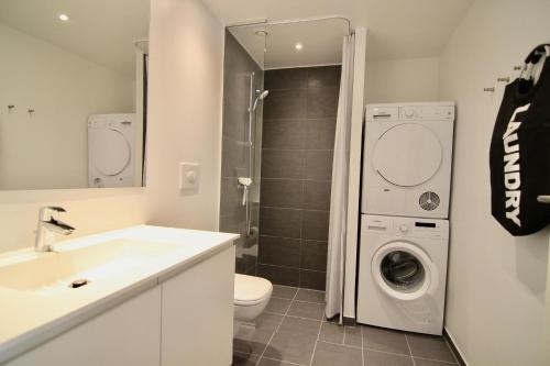 a bathroom with a sink and a washing machine at Fantastic 2-bed w balcony in Ørestaden in Copenhagen