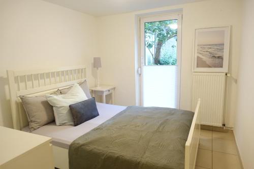 a bedroom with a large bed and a window at Terrassenwohnung 1,5 Zi mit Garten in Bremen