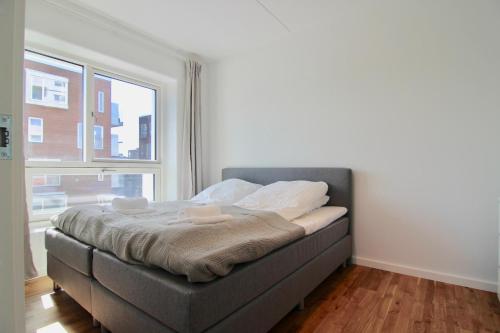 a bed in a room with a large window at Great 2-bed w balconies and awazing views in Copenhagen