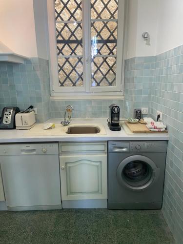 une cuisine avec un évier et une machine à laver dans l'établissement Surplombant le port de Beaulieu sur mer, à Beaulieu-sur-Mer