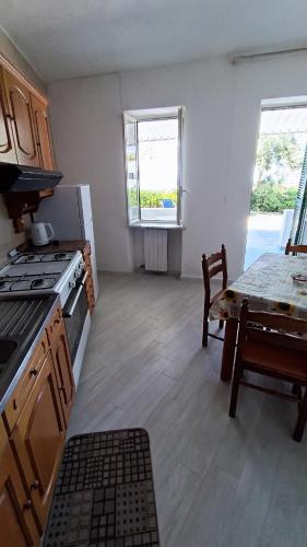 a kitchen with a stove and a table in it at La Dea del Mare in Ischia