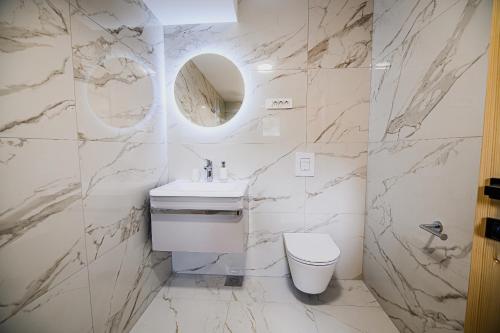 a white bathroom with a sink and a toilet at B&B Mio Nonno Rooms Ljubljana Ex Bizeljčan Rooms in Ljubljana