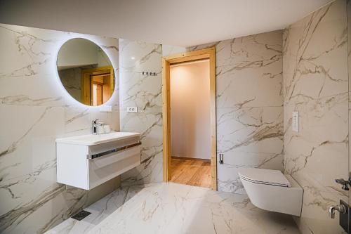 a white bathroom with a sink and a mirror at B&B Mio Nonno Rooms Ljubljana Ex Bizeljčan Rooms in Ljubljana