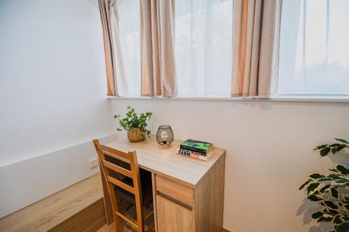 a wooden table and chair in a room with a window at B&B Mio Nonno Rooms Ljubljana Ex Bizeljčan Rooms in Ljubljana