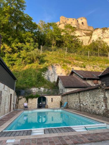 une piscine avec un château en arrière-plan dans l'établissement Villa du Vieux Château, aux Andelys